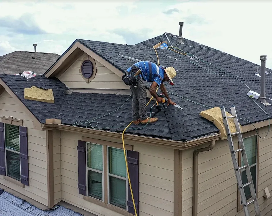 Envzn roofer installing ridge cap shingles on a Houston home